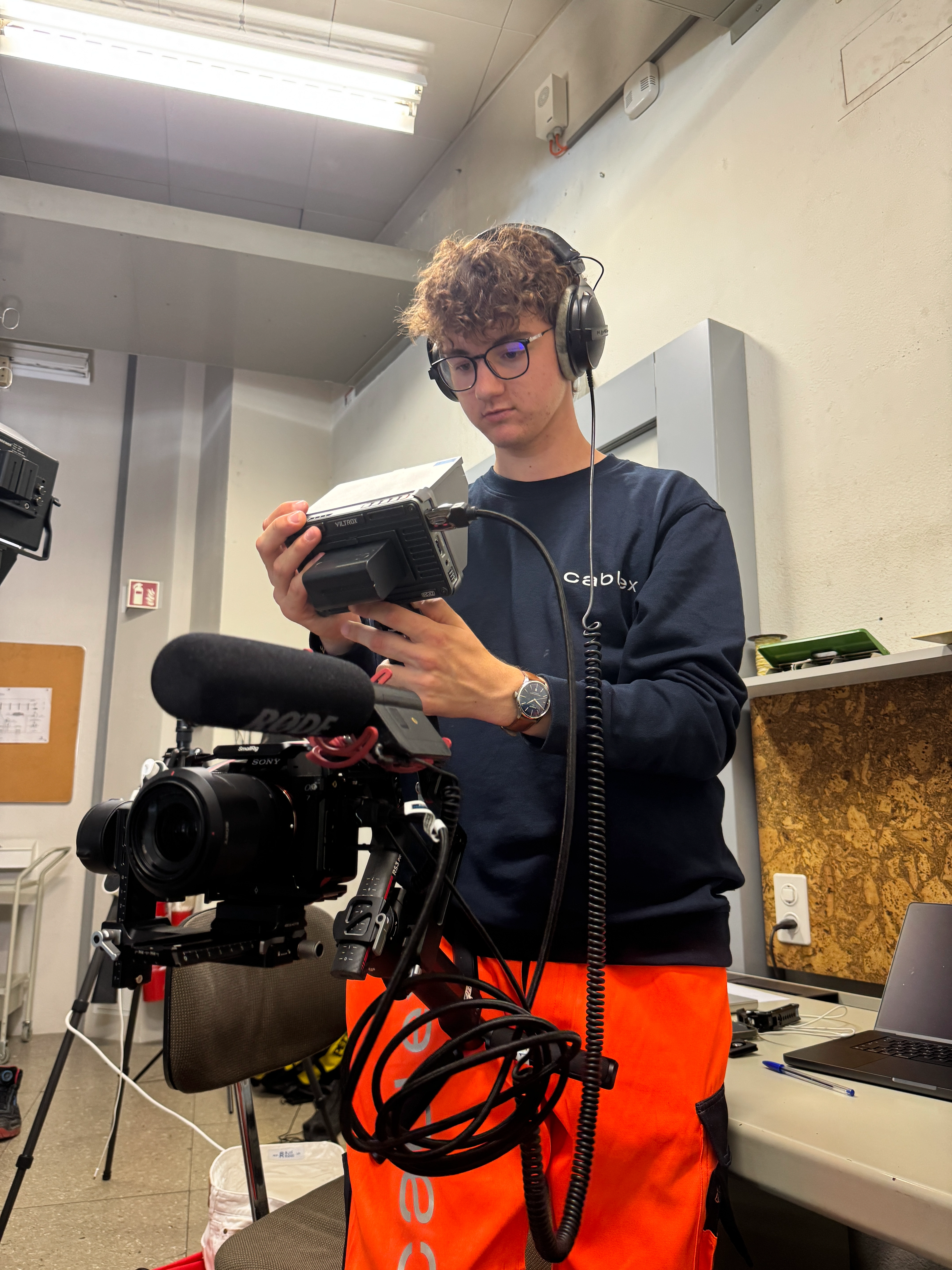 Paul filmt mit einer Kamera und einem Gimbal in einer Telefonzentrale von cablex im Swisscom Gebäude an der Genfergasse in Bern.
